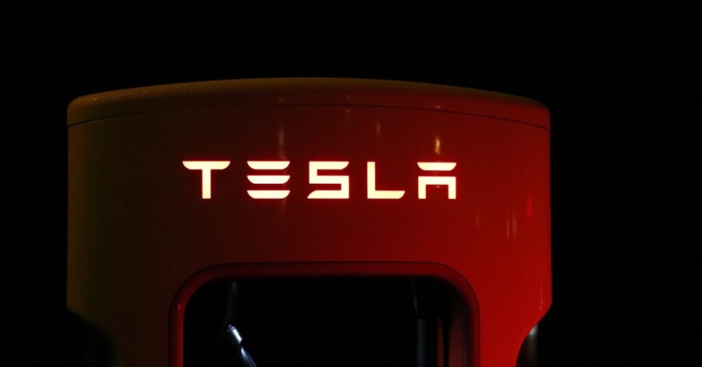 Close-up of a Tesla charging station illuminated at night, showcasing modern automotive technology.
