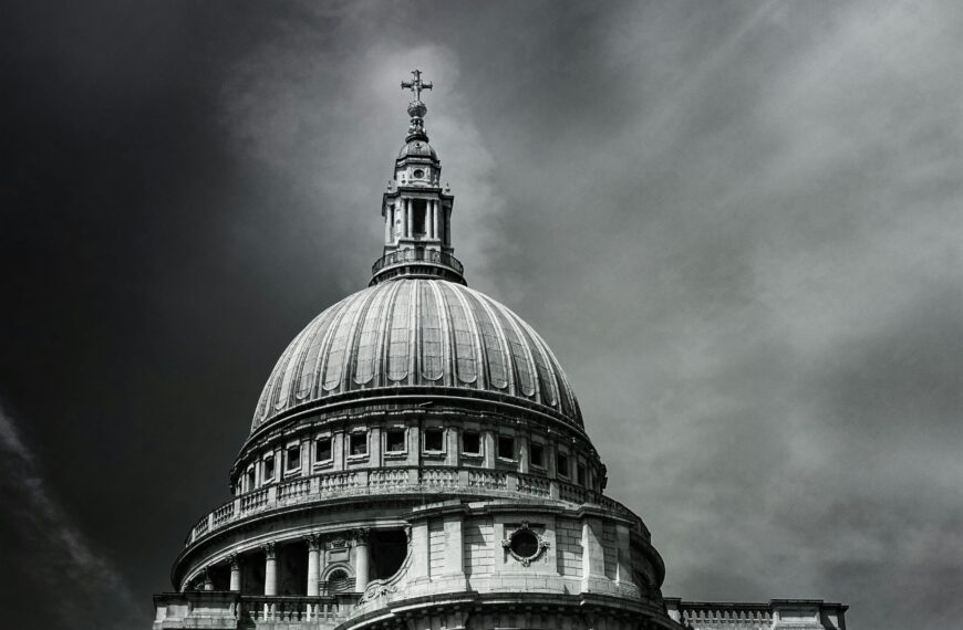 Black and white photo of the iconic St. Paul's Cathedral dome against dramatic skies.
