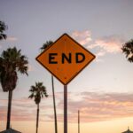 End sign amidst palm trees and sunset sky in Santa Monica, Los Angeles.