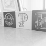 Elegant monochrome blocks spell out 'HOPE' on a reflective surface.